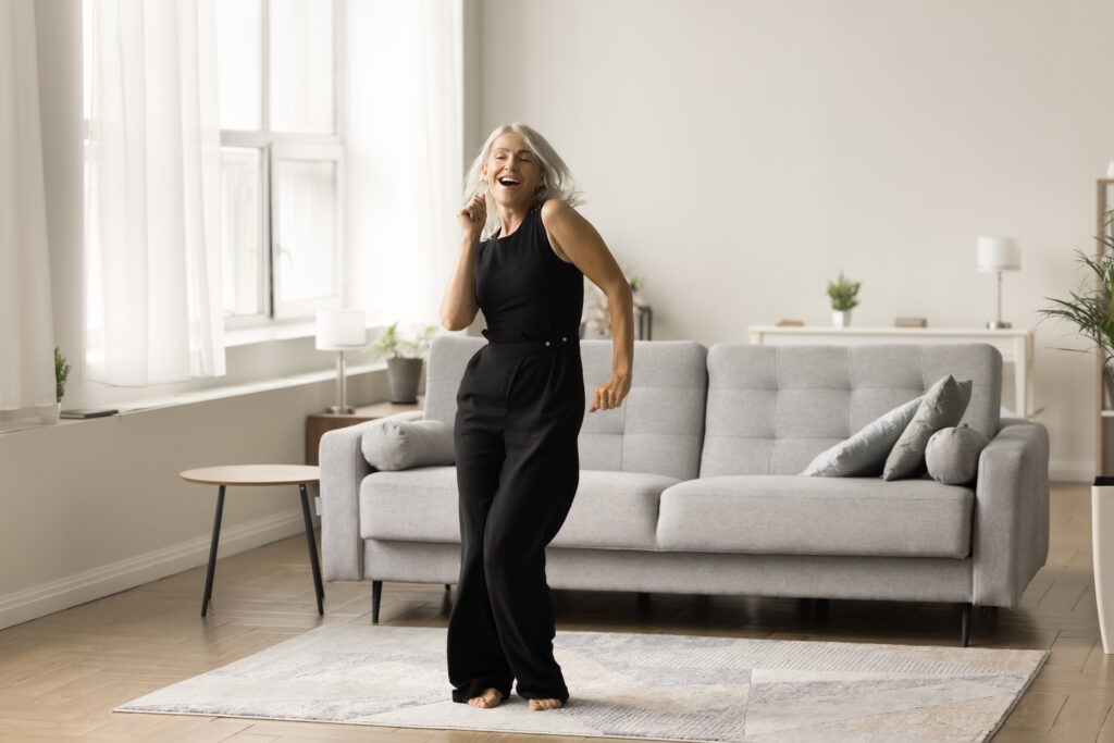 joyful active senior lady excited with single dance at home